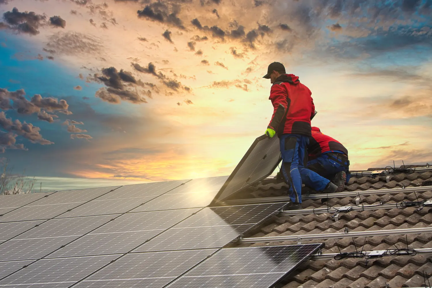 Installation einer Photovoltaik-Solaranlage. Solarpanel-Techniker installiert Solarmodule auf dem Dach.